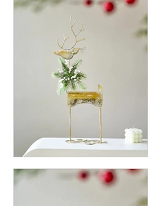 Detail showing vintage gold iron reindeer sculpture with bird ornament and festive greenery