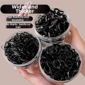 Set of thick black elastic hair ties stored in three clear cylindrical plastic containers