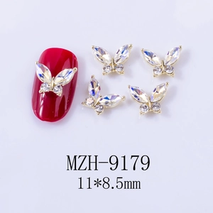 Macro shot of 11x8.5mm golden alloy butterfly nail charm with iridescent aurora rhinestone