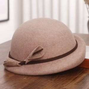 Detail of wool beret showing camel felt texture and decorative brown ribbon bow