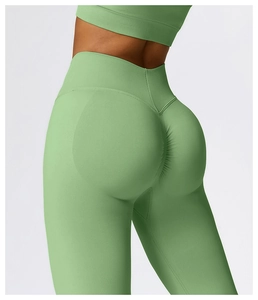 Close-up of light green high-waisted yoga pants with ribbed waistband and scrunch butt detail