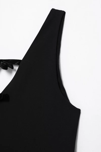 Détail d'une robe noire sans manches avec un nœud en velours délicat sur la bandoulière