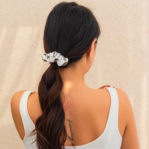 Detailed view of silver liquid metal hair clip styled on a low ponytail hairstyle