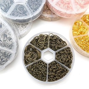 Assorted open jump rings in various metal finishes stored in a multi-grid organizer box