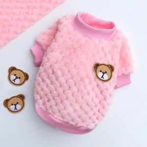 Dettaglio maglione rosa per animali in flanella con trama a rombi e ricamo di un orsetto