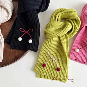 Detailed knit texture of colorful winter scarves with bow accents and soft pom-poms