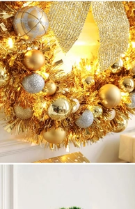 Close-up of golden Christmas wreath with luxury ornaments and warm LED lights