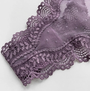 Detailed macro view of purple floral lace fabric with delicate polka dot mesh patterns