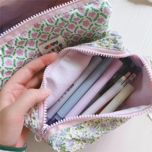 Detalle de estuche de lona floral con gran capacidad para papelería y cremallera rosa