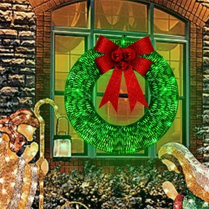 Christmas wreath with a large red bow and LED lights on a rustic brick wall