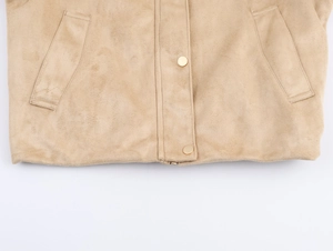 Détail d'une veste en daim kaki montrant la texture douce et la poche à bouton