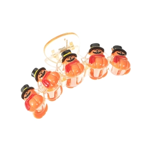 Detail of Halloween hair clip with five orange pumpkins wearing black hats on white background