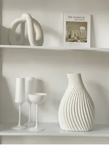 Close-up of white ceramic vase with unique spiral texture in a minimalist home setting