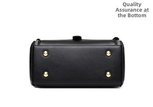 Detailed bottom view of black leather bag featuring four protective gold metal feet