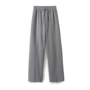 Detail of grey wide-leg sweatpants with elastic drawstring waist and vertical seam stitching