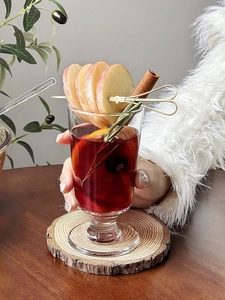 Close-up of elegant Christmas mulled wine glass with cinnamon stick and apple slices