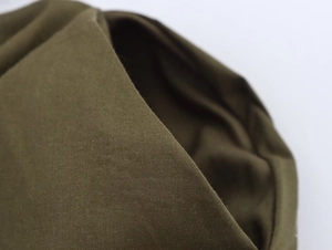 Gros plan du tissu de la robe midi plissée vert olive montrant la texture fine