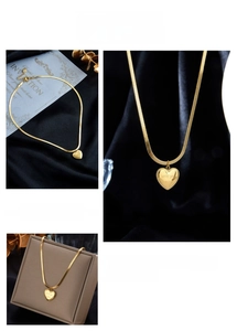 Macro shot of gold heart pendant with love you more engraving on flat snake chain