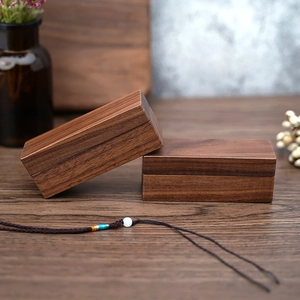 Detailed close-up of dark walnut wood ring boxes with elegant grain and smooth texture