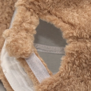 Detailed close-up of brown teddy fleece baseball cap with white adjustable back strap