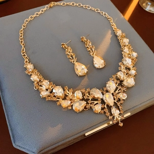 Detailed view of teardrop crystal necklace and earring set on blue velvet box