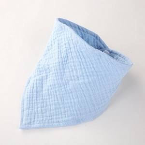 Détail d'un bavoir bébé en mousseline bleu clair avec texture douce et bouton pression