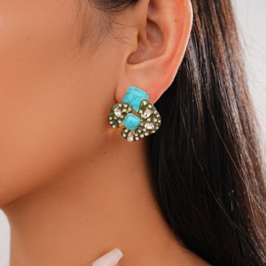 Close-up of retro acrylic cluster stud earring with blue stones and crystals on model