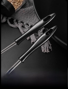 Detail of ergonomic black handle with hanging hole on a stainless steel food strainer
