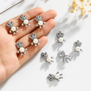 Hand holding nine silver bear pendants with freshwater pearls and sparkling zircons