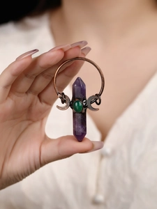 Close-up of bronze pendant with purple amethyst pillar, green stone and mystic moon detail