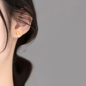 Elegant two-tone rose stud earrings in gold and silver finish shown on model