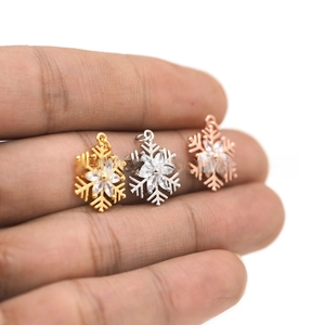 Detailed view of three-color snowflake pendants with zircon inlay for DIY jewelry