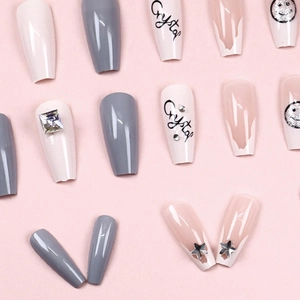 Long press-on nails with star rhinestones, smiley face design, and pink crystal finish
