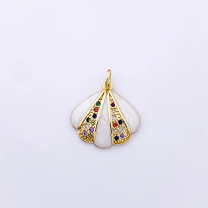 Macro d'un pendentif coquillage doré avec incrustation blanche et zircons colorés