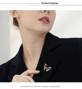 Detailed view of a red and gold butterfly brooch with rhinestones on a black blazer lapel