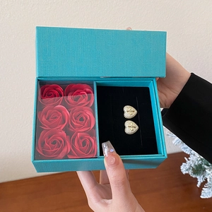 Teal jewelry box with six red roses and gold heart earrings featuring crystal crosses