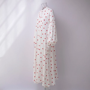 Détail d'une robe en coton avec manches bouffantes et motifs cœurs rouges