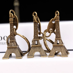 Vintage bronze Eiffel Tower keychain set with France Paris engraving on black background