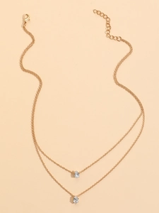 Detailed macro view of a double-layered gold necklace with two pear-cut zircon pendants