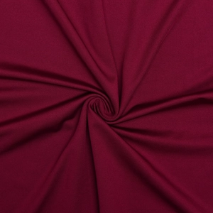 Macro detail of wine red knitted fabric with soft texture and spiral draped folds