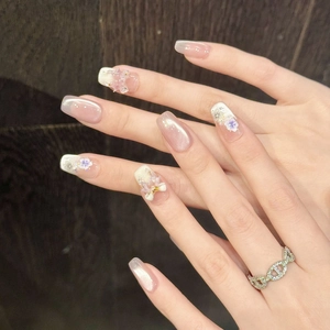 Detail of long squoval press-on nails with cat-eye effect and 3D floral accents