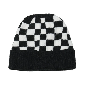 Detail of checkered knit beanie with classic black and white pattern and ribbed cuff
