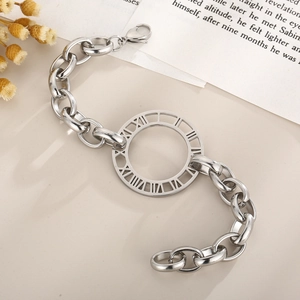 Detailed view of silver thick chain bracelet with Roman numeral pendant on vintage paper