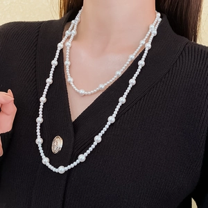 Close-up of double-layered pearl necklace with large and small beads on model