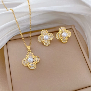 Close-up of gold tone jewelry set with teardrop pearls and pavé cubic zirconia