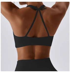 Detail of minimalist criss-cross back straps on a black athletic yoga bra for women