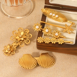 Kit de barrettes dorées avec fleurs en perles et coquillages sur une boîte à bijoux en bois