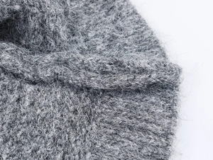 Gros plan détaillé sur un tricot gris crocheté avec une texture douce en mohair