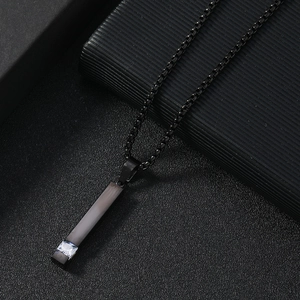Detailed macro view of black stainless steel box chain necklace with zircon square pendant