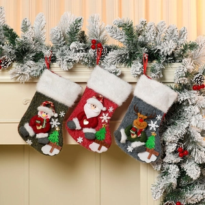 Three plush Christmas stockings with Santa, snowman and reindeer on a white fireplace